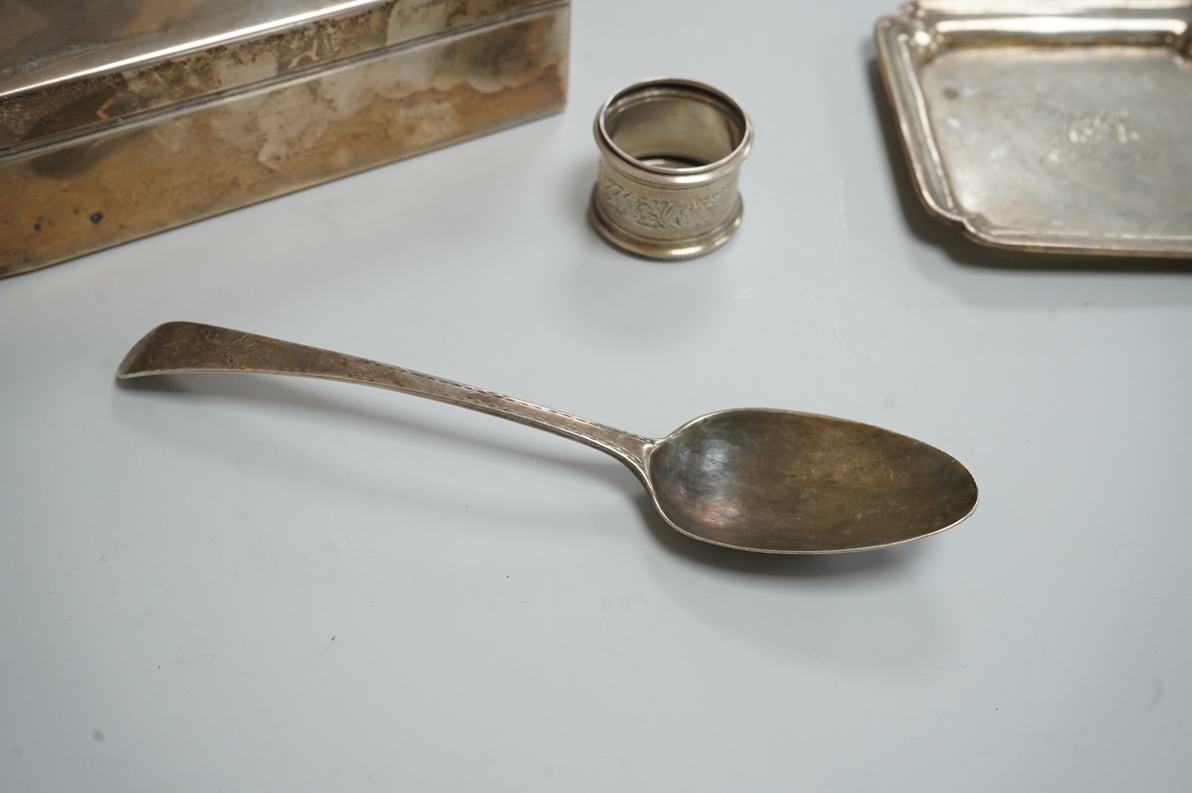 A George VI silver mounted rectangular cigarette box, Atkin Brothers, London, 1944, 17.3cm, together with a small silver dish, William Comyns & Sons Ltd, London, 1945, an Edwardian silver napkin ring and a George III sil